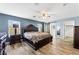 Spacious main bedroom with natural light, a ceiling fan, wood-look floors, and barn door to bathroom at 6429 Pronghorn Ridge Ave, Las Vegas, NV 89122