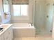 Modern bathroom featuring a soaking tub and glass-enclosed shower with neutral colors and upscale fixtures at 6507 Dove Point Pl, Las Vegas, NV 89130
