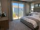 Bright bedroom with sliding glass doors opening to a balcony with views of the neighborhood at 6507 Dove Point Pl, Las Vegas, NV 89130