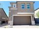Two-story home features neutral paint, stone accents, a two-car garage, and manicured landscaping at 6507 Dove Point Pl, Las Vegas, NV 89130