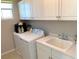 Bright laundry area with white cabinets, utility sink, and modern washer/dryer at 6507 Dove Point Pl, Las Vegas, NV 89130