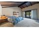Expansive primary bedroom features a wood beam ceiling and sliding door with backyard view at 6998 Alamitos Cir, Las Vegas, NV 89120