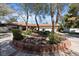 Home with circular driveway and lush landscaping features mature trees at 6998 Alamitos Cir, Las Vegas, NV 89120