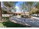 Beautiful home exterior with circular driveway, lush landscaping, and mature trees at 6998 Alamitos Cir, Las Vegas, NV 89120
