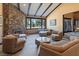 Spacious living room with stone fireplace, beamed ceilings, and large windows at 6998 Alamitos Cir, Las Vegas, NV 89120