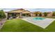 Expansive backyard featuring a pool, spa, covered patio, and lush artificial grass at 7310 Southern Magnolia St, Las Vegas, NV 89149