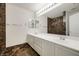 Bathroom featuring double vanity, marble-look floors and shower, and bright vanity lighting at 827 Happy Sparrow Ave, Henderson, NV 89052