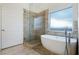 Bright bathroom featuring a luxurious soaking tub next to a separate glass-enclosed shower at 827 Happy Sparrow Ave, Henderson, NV 89052