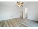 Bright bedroom with wood-look floors and ceiling fan, flowing into the en suite bathroom at 827 Happy Sparrow Ave, Henderson, NV 89052