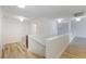 Bright hallway featuring wood-look flooring, white walls and banister, and recessed lighting at 827 Happy Sparrow Ave, Henderson, NV 89052