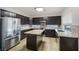 Modern kitchen with stainless steel appliances, dark wood cabinets, and granite countertops at 827 Happy Sparrow Ave, Henderson, NV 89052