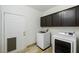 Modern laundry room with appliances and dark wood cabinets at 827 Happy Sparrow Ave, Henderson, NV 89052