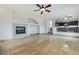 Open living area with tile floors, white walls, fireplace, and ceiling fan next to open kitchen at 827 Happy Sparrow Ave, Henderson, NV 89052