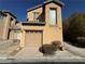 Tan two-story home with a one-car garage and desert landscaping against a blue sky backdrop at 8428 Viansa Loma Ave, Las Vegas, NV 89149