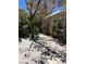 Cozy backyard with a concrete patio surrounded by flowering trees and shrubs at 8988 Dusseldorf Way, Las Vegas, NV 89147