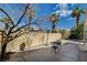 A backyard with chairs and palm trees against a clear blue sky at 8988 Dusseldorf Way, Las Vegas, NV 89147