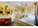 A nicely decorated bedroom with a red chair, shelves, and view of the bathroom at 8988 Dusseldorf Way, Las Vegas, NV 89147