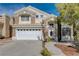 Charming two-story home featuring a large front yard, two-car garage, and stone and stucco facade at 8988 Dusseldorf Way, Las Vegas, NV 89147