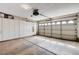 An empty garage with storage cabinets and a large roll-up door at 8988 Dusseldorf Way, Las Vegas, NV 89147