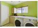 Well-lit laundry room features a modern washer and dryer, cabinets, a counter, and a window at 8988 Dusseldorf Way, Las Vegas, NV 89147