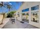 Charming patio area with black metal seating, large windows, and well-manicured landscaping at 8988 Dusseldorf Way, Las Vegas, NV 89147