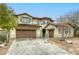 Beautiful two-story home featuring a three car garage and desert landscaping at 9160 Moose Country Pl, Las Vegas, NV 89178