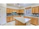 Bright kitchen featuring wooden cabinets, granite countertops, tile backsplash, and a functional center island at 9160 Moose Country Pl, Las Vegas, NV 89178