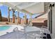 Covered patio with outdoor seating offers backyard pool and mountain views at 1019 Amber Gate St, Henderson, NV 89002