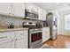 Well-lit kitchen features stainless steel appliances, tile backsplash, and granite counters at 1019 Amber Gate St, Henderson, NV 89002