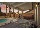 Covered patio featuring a table and chairs, perfect for outdoor dining and relaxation by the pool at 1019 Amber Gate St, Henderson, NV 89002