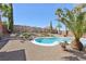 A kidney-shaped pool is surrounded by palm trees and desert landscaping against a backdrop of mountains at 1019 Amber Gate St, Henderson, NV 89002