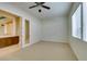 Bedroom with adjacent room, carpet, ceiling fan, and natural light at 10260 Hawks Wing St, Las Vegas, NV 89178