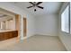 This carpeted bedroom features a ceiling fan and view to an adjacent room at 10260 Hawks Wing St, Las Vegas, NV 89178