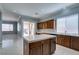 Bright kitchen featuring an island, sliding glass door to the backyard, and wooden cabinetry at 10260 Hawks Wing St, Las Vegas, NV 89178