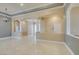 Bright living room featuring tray ceilings, decorative columns, and beautiful neutral-colored tile flooring at 10260 Hawks Wing St, Las Vegas, NV 89178