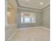 Bright living room featuring tray ceilings, decorative columns, and beautiful neutral-colored tile flooring at 10260 Hawks Wing St, Las Vegas, NV 89178