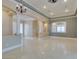 Bright living room featuring tray ceilings, decorative columns, and beautiful neutral-colored tile flooring at 10260 Hawks Wing St, Las Vegas, NV 89178