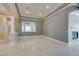 Bright living room featuring tray ceilings, decorative columns, and beautiful neutral-colored tile flooring at 10260 Hawks Wing St, Las Vegas, NV 89178