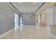 Bright living room featuring tray ceilings, chandeliers, and beautiful neutral-colored tile flooring at 10260 Hawks Wing St, Las Vegas, NV 89178