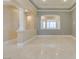 Bright living room featuring tray ceilings, decorative columns, and beautiful neutral-colored tile flooring at 10260 Hawks Wing St, Las Vegas, NV 89178