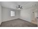 Well lit bedroom featuring neutral carpet, a ceiling fan, and views through a window at 105 Ash St, Henderson, NV 89015