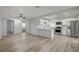 Open-concept living space featuring modern kitchen with stainless steel appliances and wood-look tile flooring at 105 Ash St, Henderson, NV 89015