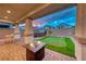 Relaxing backyard with a fire pit, mini-golf, and pavers at 122 Cabaletta Ln, Henderson, NV 89015
