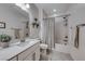 Stylish bathroom with a single sink, bathtub with shower, and decorative plants at 122 Cabaletta Ln, Henderson, NV 89015