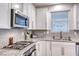Modern kitchen featuring gray herringbone backsplash and stainless steel appliances at 122 Cabaletta Ln, Henderson, NV 89015