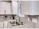 Close-up of a kitchen sink featuring granite countertops and a decorative herringbone backsplash at 122 Cabaletta Ln, Henderson, NV 89015