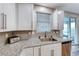 Clean kitchen sink with modern faucet, herringbone backsplash, and stainless steel dishwasher at 122 Cabaletta Ln, Henderson, NV 89015