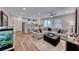 Inviting living room featuring hardwood floors and a comfortable sectional sofa adjacent to a modern kitchen at 122 Cabaletta Ln, Henderson, NV 89015