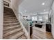 Open-concept living area showcasing stairs, wood flooring, a modern ceiling fan, and a spacious layout at 122 Cabaletta Ln, Henderson, NV 89015