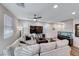 Bright and airy living room with a large sectional sofa, ceiling fan, and modern decor at 122 Cabaletta Ln, Henderson, NV 89015